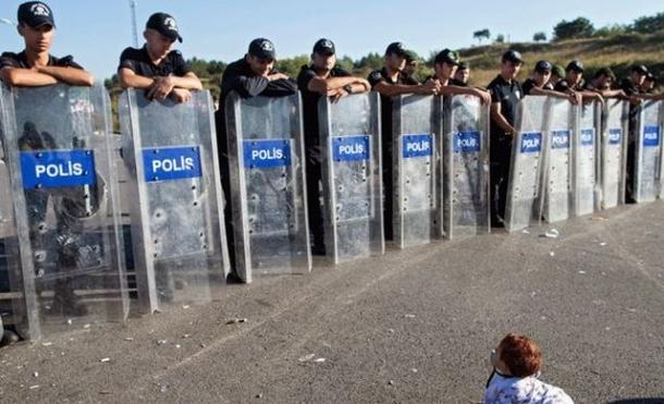Te topeşte! O FOTOGRAFIE TULBURĂTOARE:un bebeluş sirian se joacă senin în faţa cordonului de poliţişti turci 