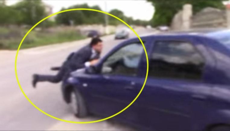 VIDEO SPECTACULOS. Un ofițer anticorupție este luat pe capota mașinii de un vameș supărat că a fost prins luând mită