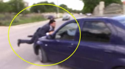 VIDEO SPECTACULOS. Un ofițer anticorupție este luat pe capota mașinii de un vameș supărat că a fost prins luând mită